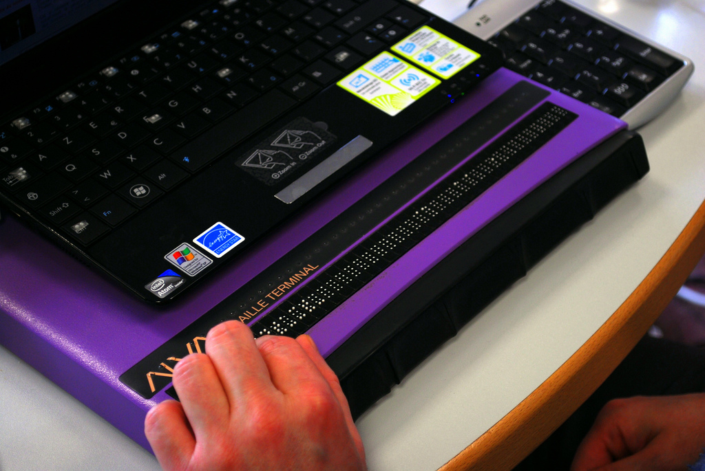 A person using a refreshable Braille display.